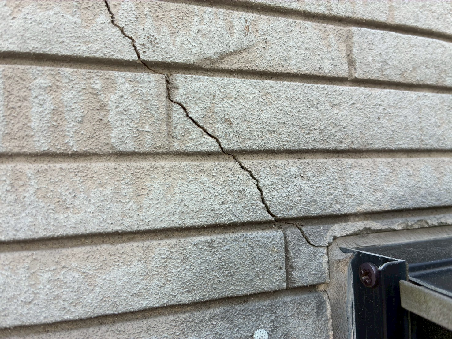 サッシの角からひび割れているサイディング外壁